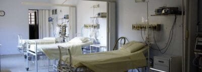 An empty intensive care bay with a bed and monitoring equipment